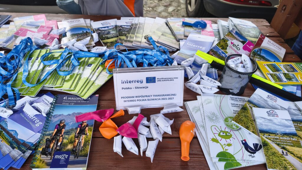 Stół z materiałami informacyjnymi i logotypem Programu podczas Jarmarku Rzemiosła Pogranicza w Starym Sączu Stôl s informačnými materiálmi a logom programu počas remeselného veľtrhu Jarmarku Rzemiosła Pogranicza v Stary Sącz