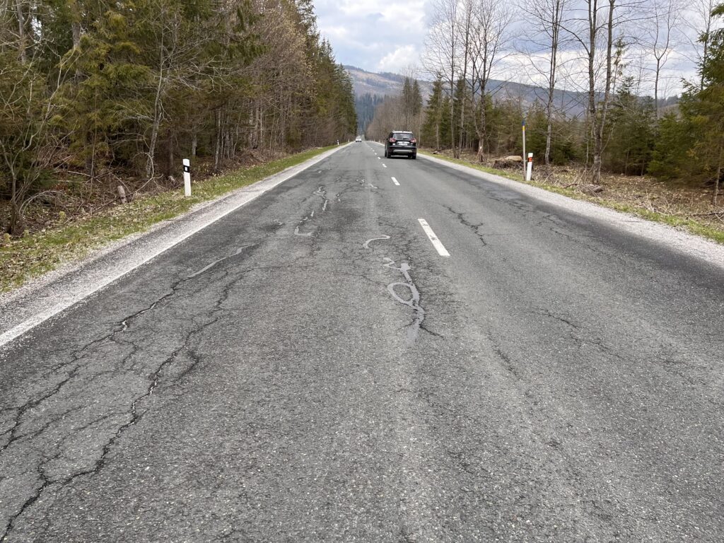 Droga w górach ze starym asfaltem i bez poboczy Cesta v horách so starým asfaltom a bez krajníc