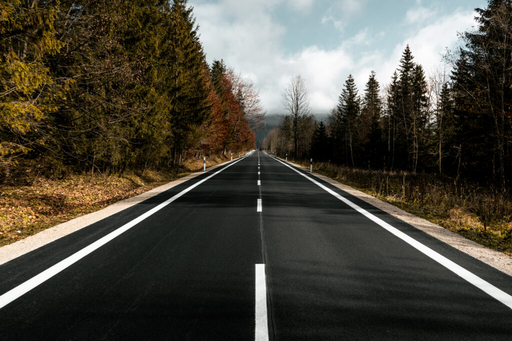 Droga w górach po remoncie z nowym asfaltem i kamienistymi poboczami Cesta v horách po oprave s novým asfaltom a kamenistými krajnicami