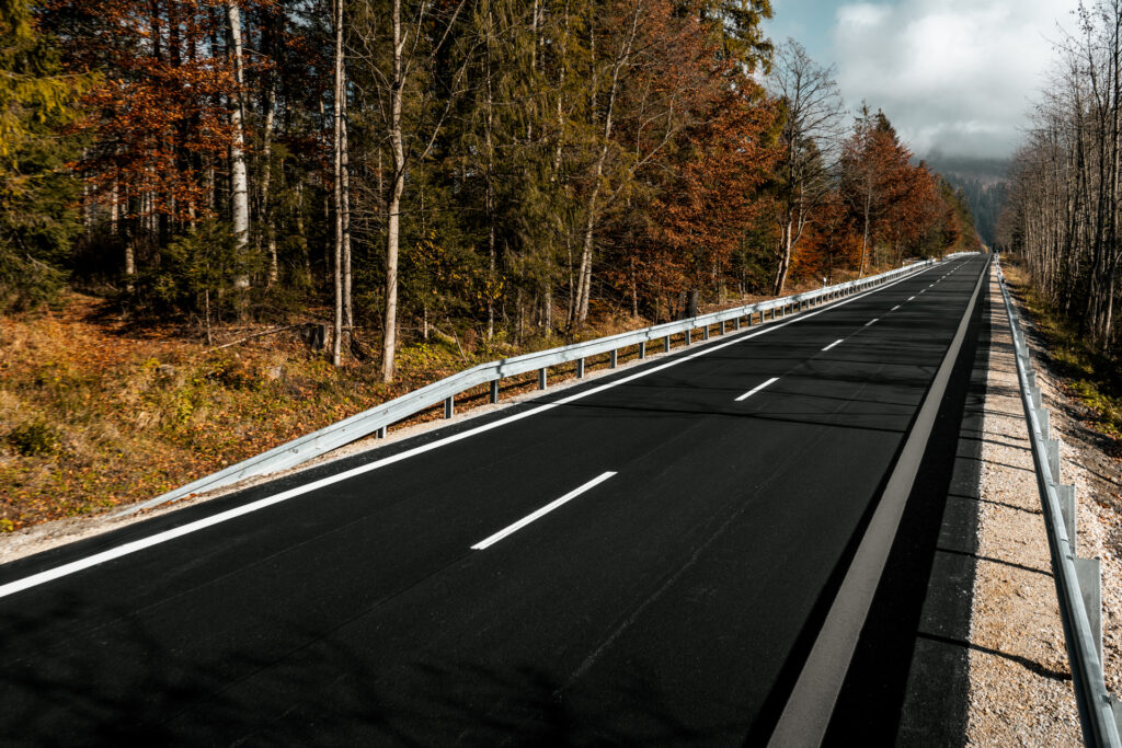 Droga w górach po remoncie z nowym asfaltem i kamienistymi poboczami Cesta v horách po oprave s novým asfaltom a kamenistými krajnicami